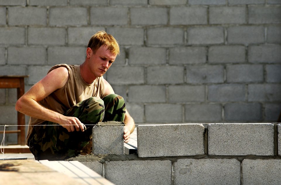 US Navy 050415-F-7823A-001 Naval Construction Battalion Unit Four Zero (NCBU-40) Constructionman Ted Macie cements bricks together