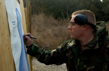 US Navy 050412-N-4614W-006 Gunner's Mate 1st Class Don Montgomery tallies teammates' scores during a 9mm pistol qualification