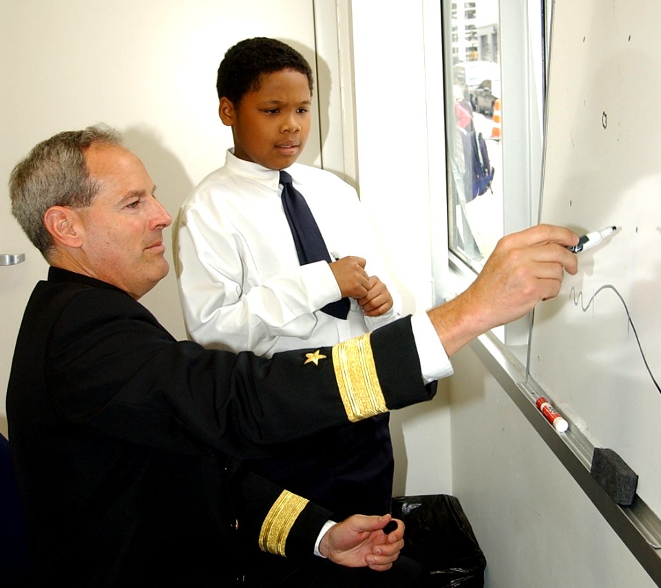 US Navy 050425-N-4729H-202 Commander, Navy Recruiting Command, Rear Adm. Jeffrey Fowler, discusses weather patterns with student Ervin Hall at the Math, Civics and Science Charter School