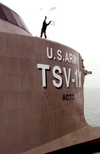 US Navy 050315-F-2902B-014 A U.S. Army 469th Transportation Detachment crew member, assigned to Theater Support Vessel TSV-1X Spearhead, throws a rope to shore for prior to mooring the vessel