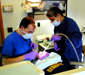 US Navy 050322-F-9933W-001 Navy Reserve Cmdr. J.C. Shirley, a Naval Reservist pediatric dentist assigned to the 4th Dental Battalion, left, and U.S. Army Sgt. Victoria Haines, a dental assistant assigned to Dental Activity-Ala