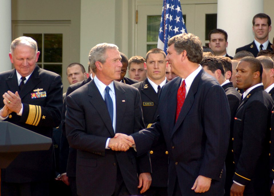 US Navy 050420-N-0000A-001 President George W. Bush shakes hands with U.S. Naval Academy Head Football Coach Paul Johnson during a ceremony at the White House