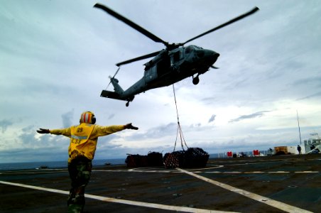 US Navy 050408-N-0357S-026 A Landing Signal Enlisted Sailor guides an MH-60S Seahawk helicopter, assigned to Helicopter Combat Support Squadron Five (HC-5), during a vertical replenishment aboard the Military Sealift Command (