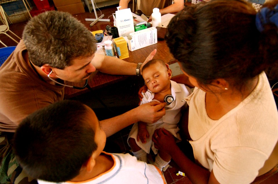 US Navy 050323-F-5435R-036 U.S. Navy Cmdr. Ron Hicks, from the Operational Support Hospital Unit, Great Lakes, Ill., examines a baby for possible illness