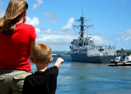 US Navy 050520-N-3019M-002 Family members of a Sailor stationed aboard the guided missile destroyer USS Chafee (DDG 90) watch as the ship leaves Pearl Harbor on her maiden deployment