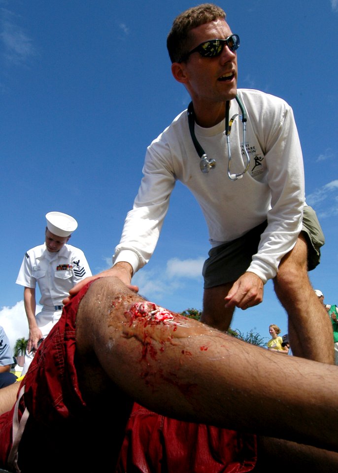 US Navy 050415-N-3019M-007 Lt. Cmdr. Geoff Keenan, assigned to Naval Health Clinic, Makalapa treats Hospital Corpsman 3rd Class Sherwyne Santos for a simulated broken leg during a mass casualty-decontamination drill