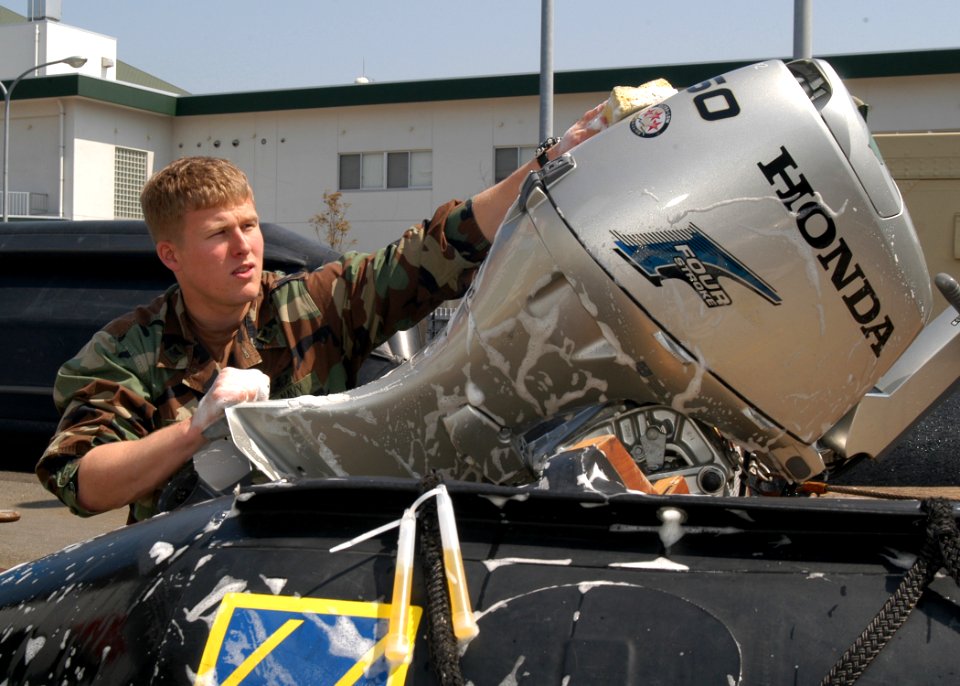 US Navy 050329-N-2385R-024 Electrician's Mate 2nd Class Daniel K. Ryan, assigned to Explosive Ordnance Disposal Mobile Unit Five (EODMU-5), Detachment Five One, washes the engine of a Combat Rubber Raiding Craft