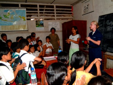 US Navy 050427-N-0357S-010 With help from an interpreter, Hospital Corpsman 2nd Class Cyrena Williams teaches a class on infectious disease to students at a school on the island of Nias, Indonesia