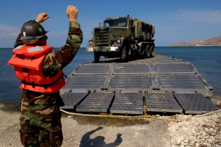 US Navy 050509-N-3642E-013 A Sailor assigned to the amphibious transport dock ship USS Austin (LPD 4) guides a five-ton truck from the Puerto Rican National Guard's 699th Engineering Company onto a causeway