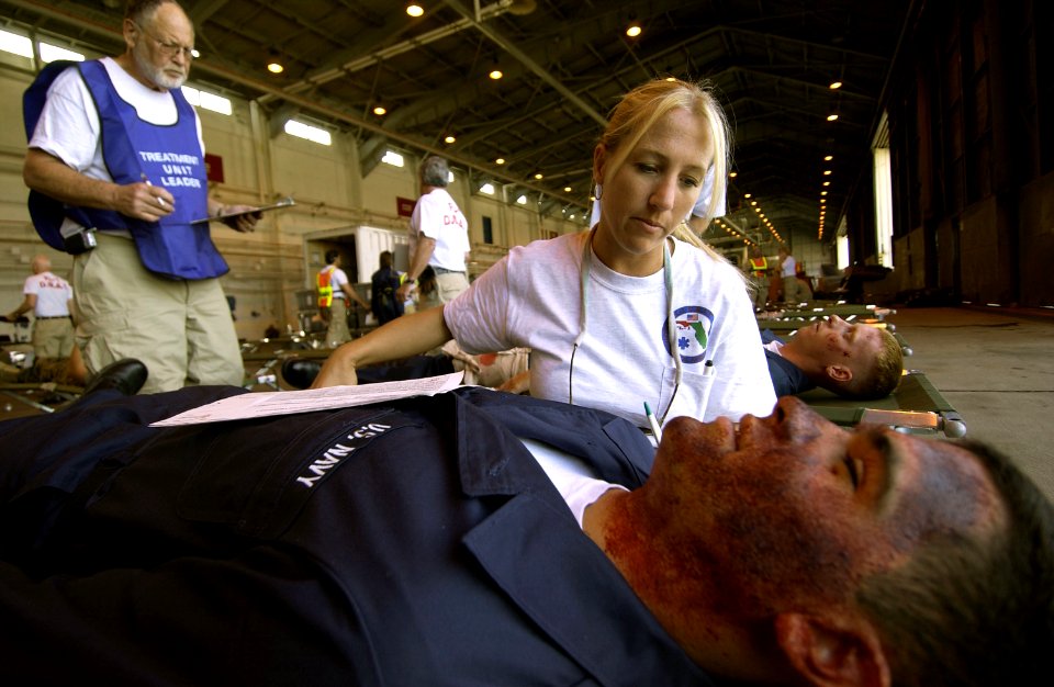 US Navy 050526-F-6655M-074 Stacey Asbury, a registered nurse for the Florida Disaster Medical Assistance Teams, assesses wounds on a simulated patient during exercise Lifesaver 2005