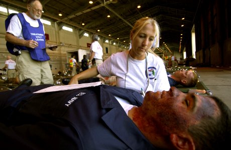 US Navy 050526-F-6655M-074 Stacey Asbury, a registered nurse for the Florida Disaster Medical Assistance Teams, assesses wounds on a simulated patient during exercise Lifesaver 2005