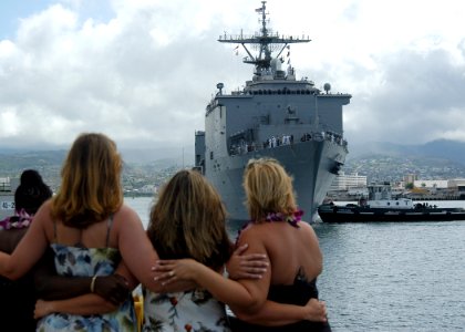 US Navy 050526-N-3019M-003 Family members of Sailors assigned to the dock landing ship USS Rushmore (LSD 47) watch as the ship arrives in Pearl Harbor
