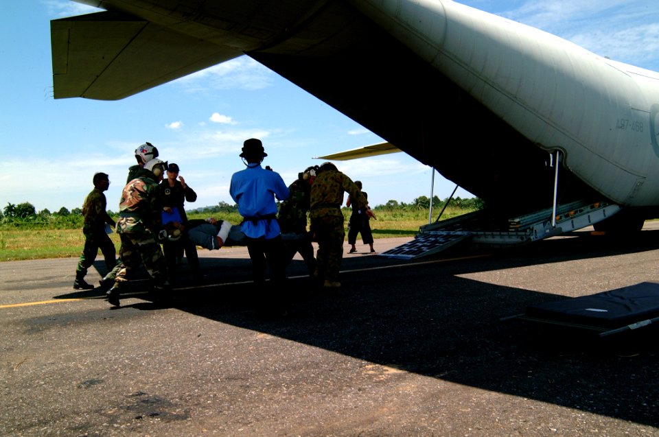 US Navy 050405-N-0357S-007 U.S. Navy Hospital Corpsmen and aircrew men assist in carrying an injured Royal Australian Navy Sailor to an awaiting C-130 Hercules aircraft