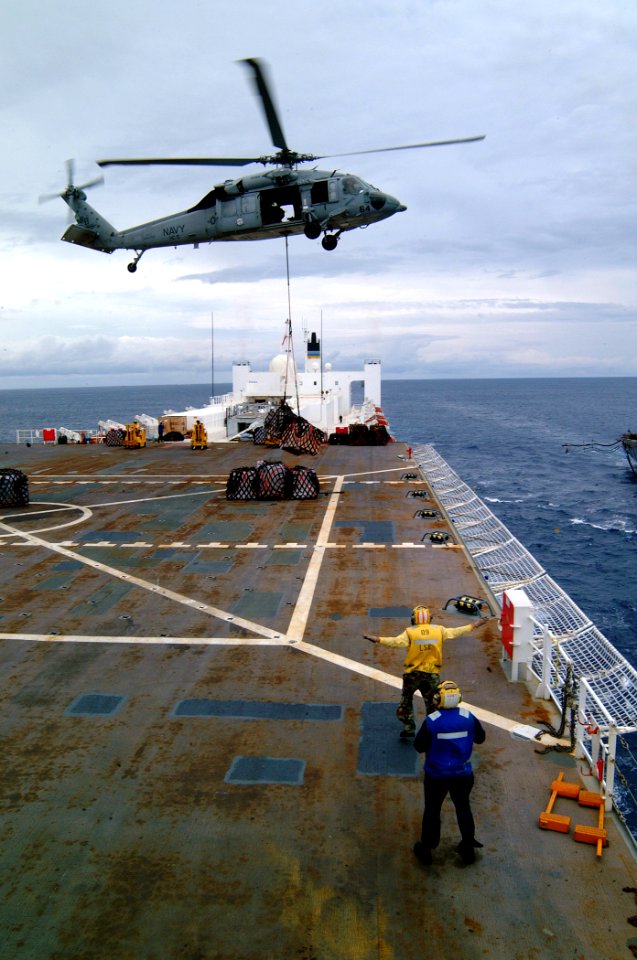 US Navy 050408-N-0357S-027 A Landing Signal Enlisted Sailor guides an MH-60S Seahawk helicopter, assigned to Helicopter Combat Support Squadron Five (HC-5), during a vertical replenishmen