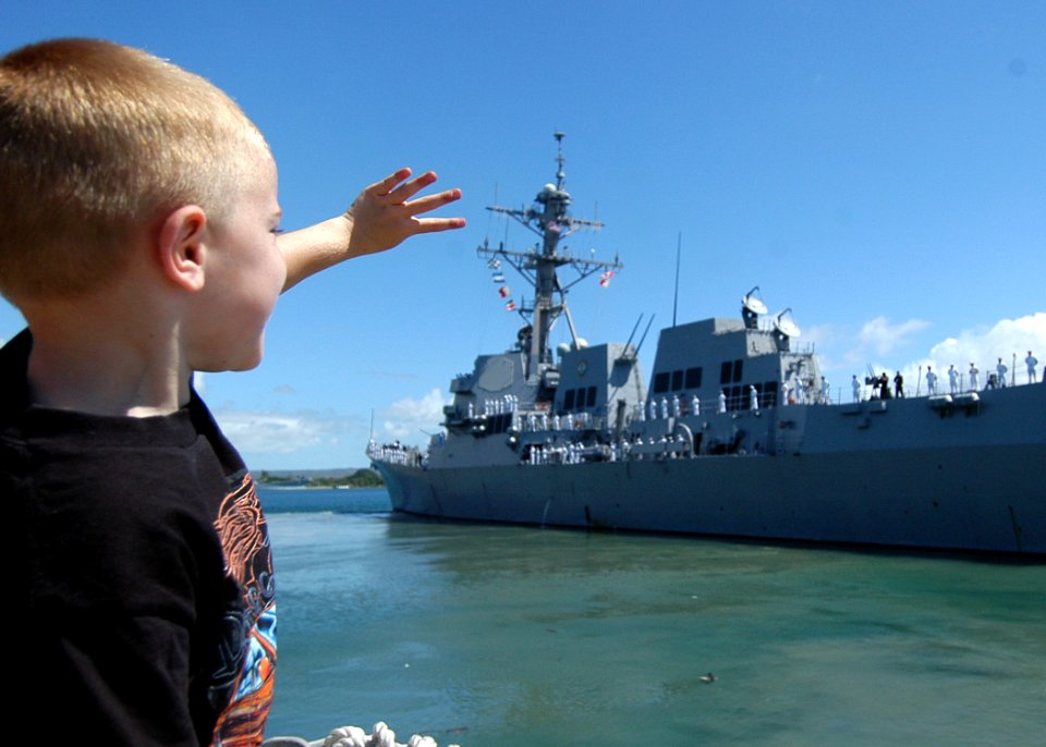 US Navy 050520-N-3019M-003 A family member of a Sailor stationed aboard the guided missile destroyer USS Chafee (DDG 90) waves goodbye to the ship as it leaves Pearl Harbor