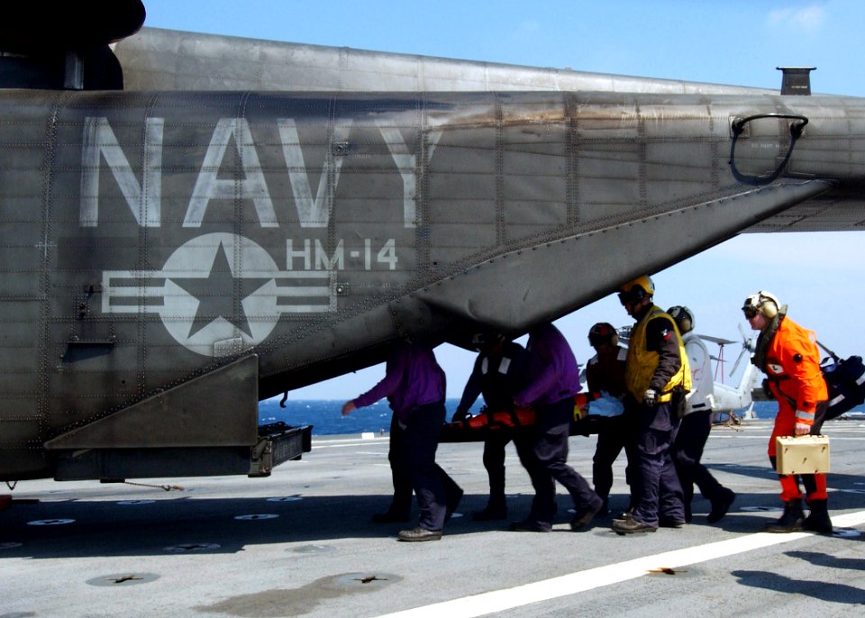 US Navy 050508-N-4374S-004 Stretcher bearers assigned to the amphibious transport dock ship USS Trenton (LPD 14), carry an 83-year old civilian, to an MH-53E Sea Dragon helicopter