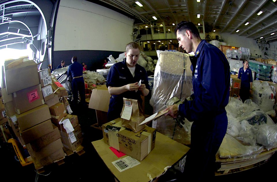 US Navy 050530-N-6781S-051 Machinist Mate 1st Class Louis Vasconez and Store Keeper 2nd Class Mari Cragun prepare supplies for distribution during a vertical replenishment