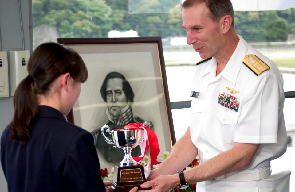 US Navy 050520-N-9851B-012 Commander Naval Forces Japan, Rear Admiral Frederic Ruehe presents a trophy to a Shimoda high school student for winning an art contest in honor of the sixty sixth annual Black Ship Festival