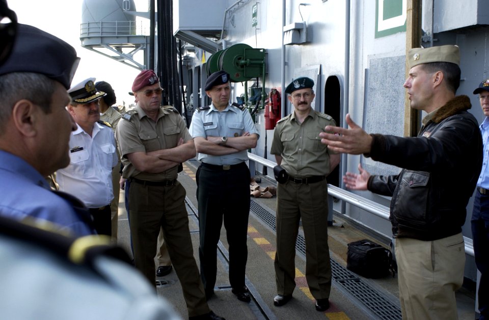 US Navy 050531-N-9866B-023 Air Boss of the amphibious assault ship USS Peleliu (LHA 5), Cmdr. James Cox, speaks to a group of Polish flag officers visiting as a delegation from the National Defense University