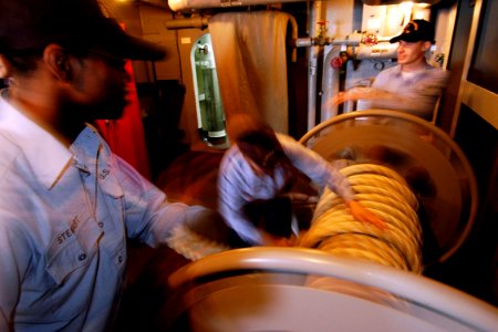 US Navy 050605-N-4166B-069 Sailors from deck department load a mooring line on to a line reel as the Nimitz-class aircraft carrier USS Abraham Lincoln (CVN 72) depart from Naval Air Station North Island photo