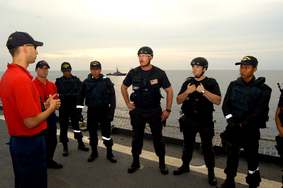 US Navy 050606-N-4104L-020 Members of the combined USS Rodney M. Davis (FFG 60) and RSS Independence visit, board, search and seizure (VBSS) team are debriefed