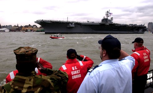 US Navy 050525-G-9539B-081 Service members from the Coast Guard and Marine Corps aboard the Coast Guard Cutter Katherine Walker render honors to USS John F. Kennedy (CV 67) as it travels up the Hudson river during the Fleet Wee