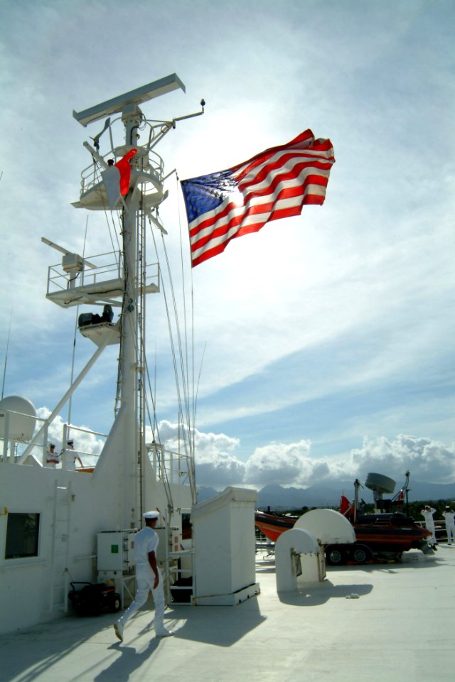 US Navy 050530-N-0357S-031 A chief petty officer passes under the American flag flying from the Military Sealift Command (MSC) hospital ship USNS Mercy (T-AH 19) as it enters Pearl Harbor, Hawaii