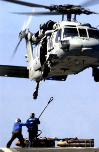 US Navy 050529-N-5549O-350 Sailors stationed aboard the Military Sealift Command (MSC) combat support ship USNS Rainier (T-AOE 7) prepare to load ordnance underneath an MH-60S Knighthawk