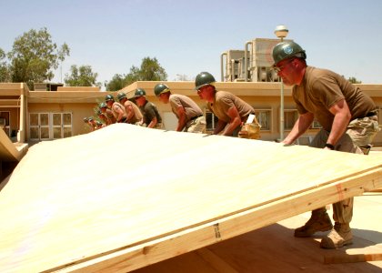 US Navy 050605-N-8102P-083 U.S. Navy Seabees assigned to Naval Mobile Construction Battalion Two Four (NMCB-24) lift a 80' wall section
