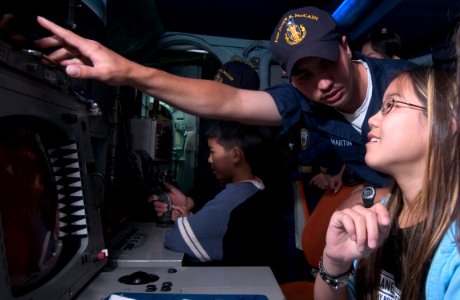US Navy 050531-N-9851B-012 Fire Controlman 3rd Class James Martin explains weapon-targeting equipment to visitors aboard the guided missile destroyer USS John S. McCain (DDG 56) photo
