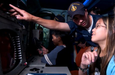 US Navy 050531-N-9851B-012 Fire Controlman 3rd Class James Martin explains weapon-targeting equipment to visitors aboard the guided missile destroyer USS John S. McCain (DDG 56)