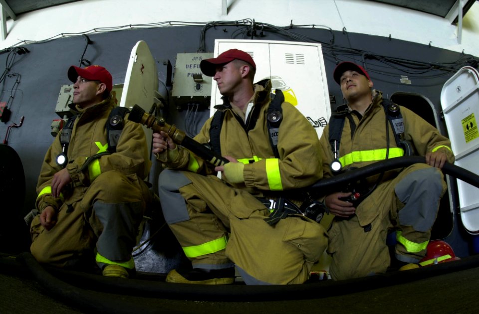 US Navy 050511-N-0361G-006 Firefighters assigned to the Engineering Department, man a fire hose in case of any emergencies during a weapons exchange