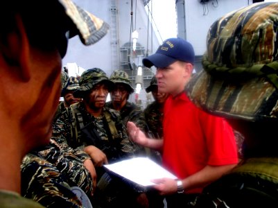 US Navy 050526-N-4104L-001 A U.S. Coast Guard law enforcement specialist debriefs members of a Philippine Navy SEAL team following a visit, board, search and seizure (VBSS) exercise aboard the dock landing ship USS Fort McHenry