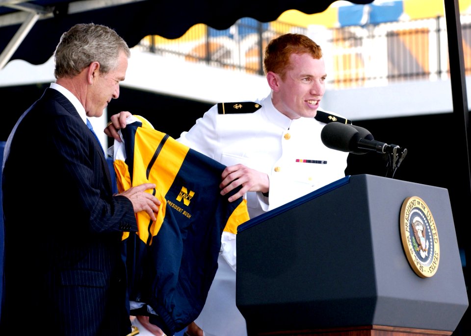 US Navy 050527-N-5390M-193 A graduating Midshipman presents U.S. President George W. Bush with a Naval Academy windbreaker jacket, during the 2005 Naval Academy Graduation Ceremony