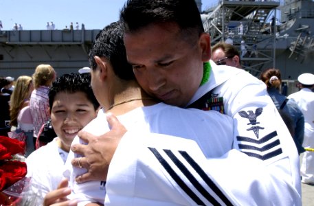 US Navy 050606-N-9866B-047 A Sailor assigned to the amphibious dock landing ship USS Duluth (LPD 6) hugs his son after returning from a six-month deployment