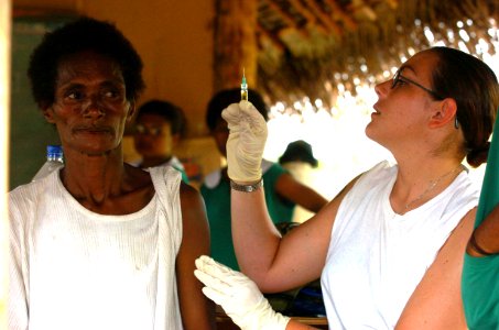 US Navy 050518-N-1485H-006 Hospitalman Jessica Mayer of Mariss, Ill., preps a syringe filled with measles, mumps and rubella vaccination before injecting a local woman the local village of Potts Dam