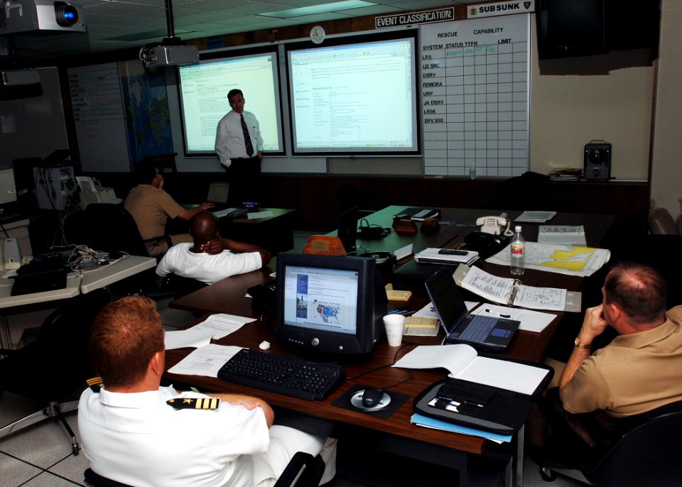 US Navy 050614-N-1464F-010 Coordinator for the International Submarine Escape and Rescue Liaison Office (ISMERLO), Bill Orr, top left, gives a situation brief after being notified about a simulated disabled submarine as part of