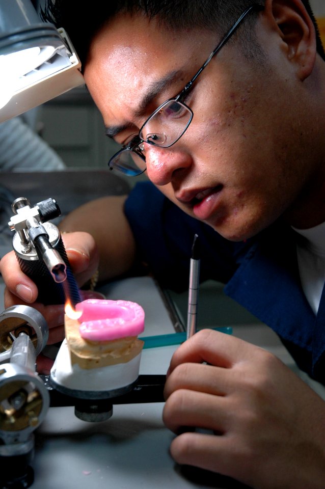 US Navy 050625-N-8158F-019 Dental Technician 3rd Class Ryan Antonio from San Diego, Calif., sculpts a mouth guard for a crewmember aboard the nuclear-powered aircraft carrier USS Nimitz (CVN 68)