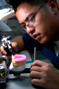US Navy 050625-N-8158F-019 Dental Technician 3rd Class Ryan Antonio from San Diego, Calif., sculpts a mouth guard for a crewmember aboard the nuclear-powered aircraft carrier USS Nimitz (CVN 68)