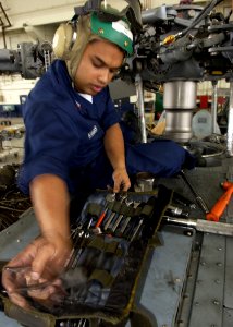 US Navy 050609-N-7286M-135 Aviation Machinist's Mate 1st Class Imran Kamiss of Anaheim, Calif., diligently works on an SH-60F Seahawk helicopter's rotor blades