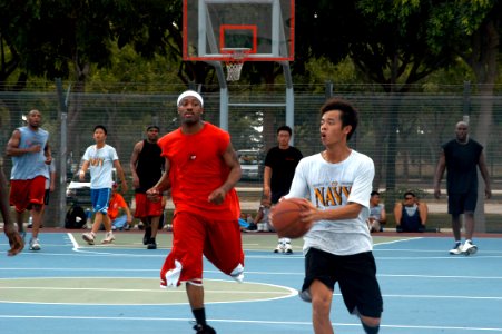 US Navy 050610-N-4104L-003 Engineman 3rd Class Ramel Cade, assigned to USS Fort McHenry (LSD 43), chases in pursuit of the basketball during a combined U.S. Navy and Republic of Singapore Navy sports day