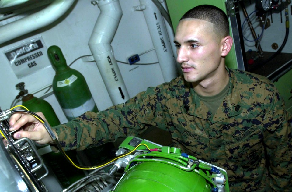 US Navy 050628-N-0361G-010 U.S. Marine Corps Sgt. Juan Franco tests and checks an aircraft oxygen tank using an oxygen converter aboard the nuclear-powered aircraft carrier USS Nimitz (CVN 68)