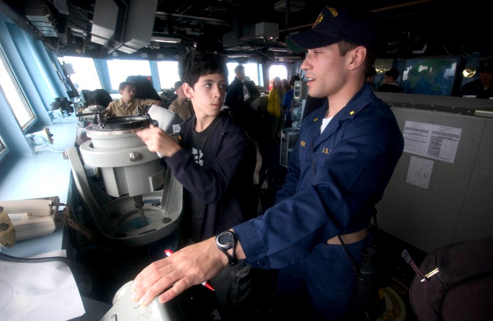 US Navy 050531-N-9851B-018 First Lieutenant, Ens. Nicholas Leshock explains the ship's compass on the bridge of the guided missile destroyer USS John S. McCain (DDG 56)