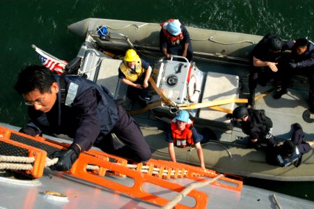 US Navy 050604-N-4104L-005 Republic of Singapore Navy Staff Sgt. Chiow Cheng Hai comes aboard the dock loading ship USS Fort McHenry (LSD 43) during a combined visit board, search and seizure (VBSS) exercise
