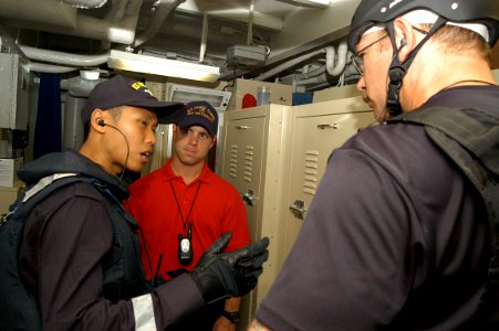 US Navy 050606-N-4104L-009 Republic of Singapore Navy Lt. Norman Quek and his combined visit, board, search and seizure (VBSS) team partner Chief Gunner's Mate Ross McDonell share information