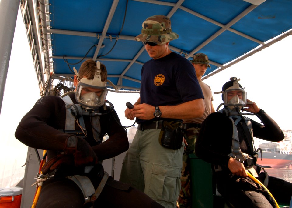 US Navy 050610-N-2385R-057 U.S. Navy divers assigned to the Ships Repair Facility- Japan Regional Maintenance Center, Detachment Sasebo get assistance with their gear in preparation for a diving evolution