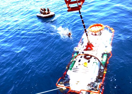 US Navy 050620-N-1464F-026 Petty Officer 3rd Class Richard Russell swims out to the United Kingdom's submarine rescue vehicle LR-5 to unhook the crane as it was lowered off the Finnish ship Fennica
