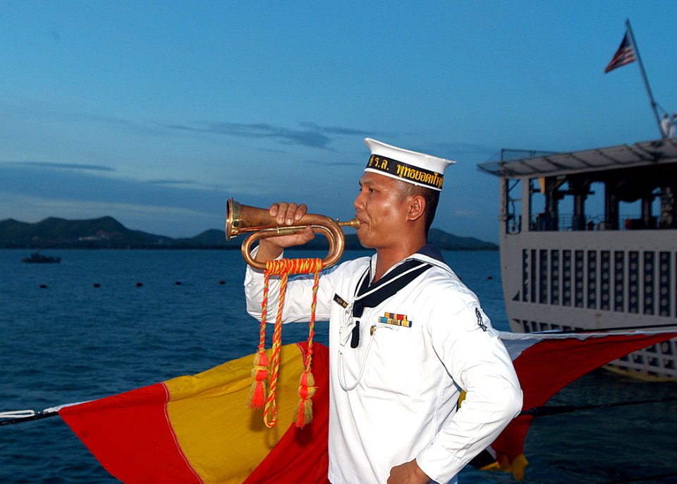 US Navy 050621-N-4104L-040 A Royal Thai Navy bugler aboard HTMS Phutthayotfa Chulalok sounds a call marking evening colors A Royal Thai Navy bugler aboard HTMS Phutthayotfa Chulalok sounds a call marking evening colors