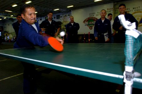 US Navy 050623-N-9866B-023 Disbursing Clerk 1st Class Roel Edralin concentrates as he hits a ping-pong ball