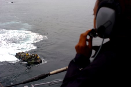 US Navy 050615-N-9866B-008 Seaman Ebony Starr uses a sound-powered telephone to reply the progress of amphibious assault vehicles, assigned to the 3rd Amphibious Assault Battalion, as it prepares to enter the well deck of the a